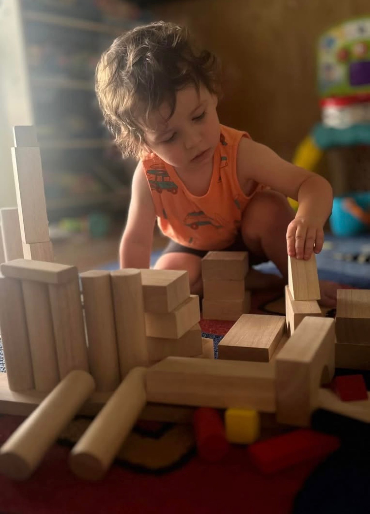 Toddler building a tower with wooden blocks