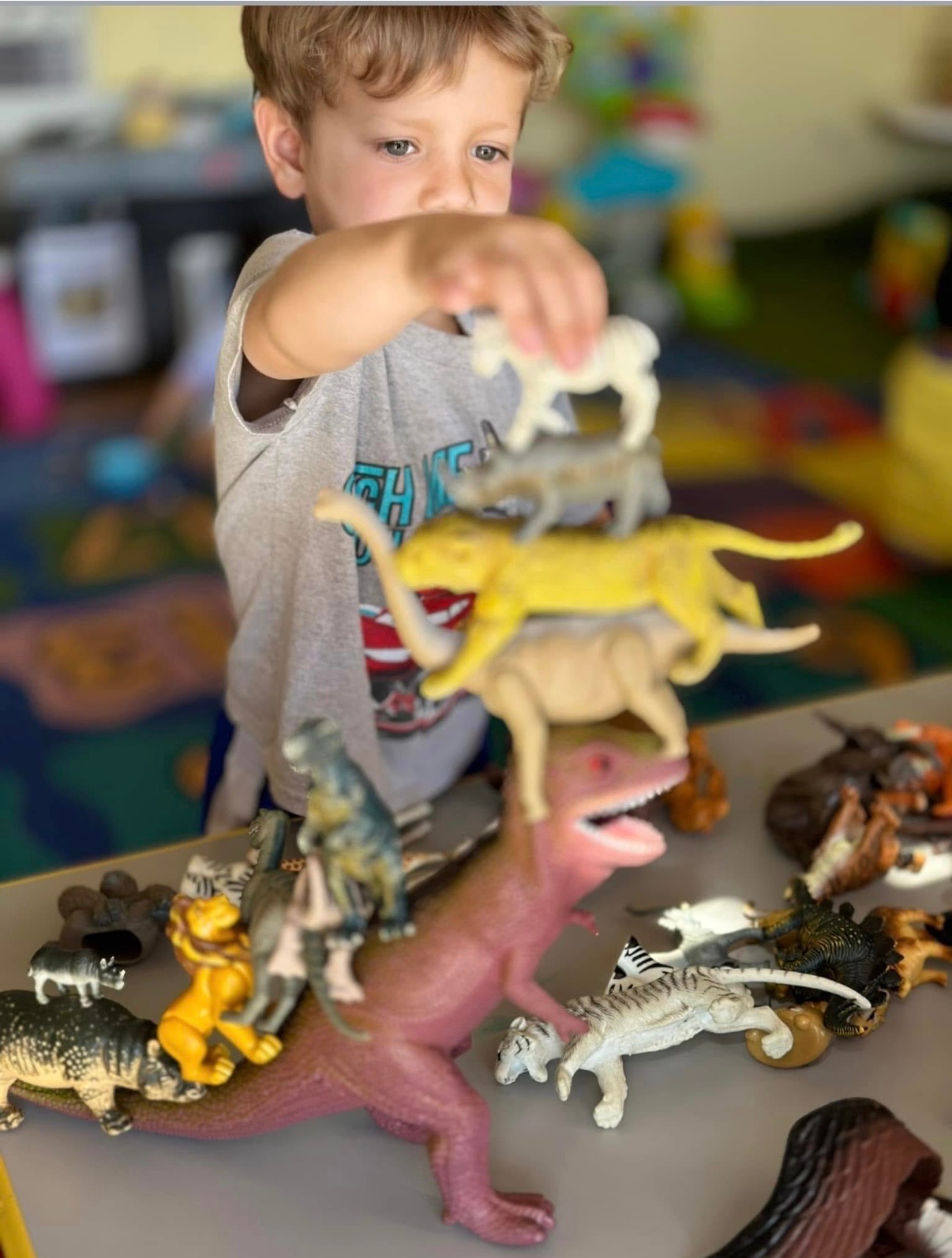Child stacking toy animals during imaginative play